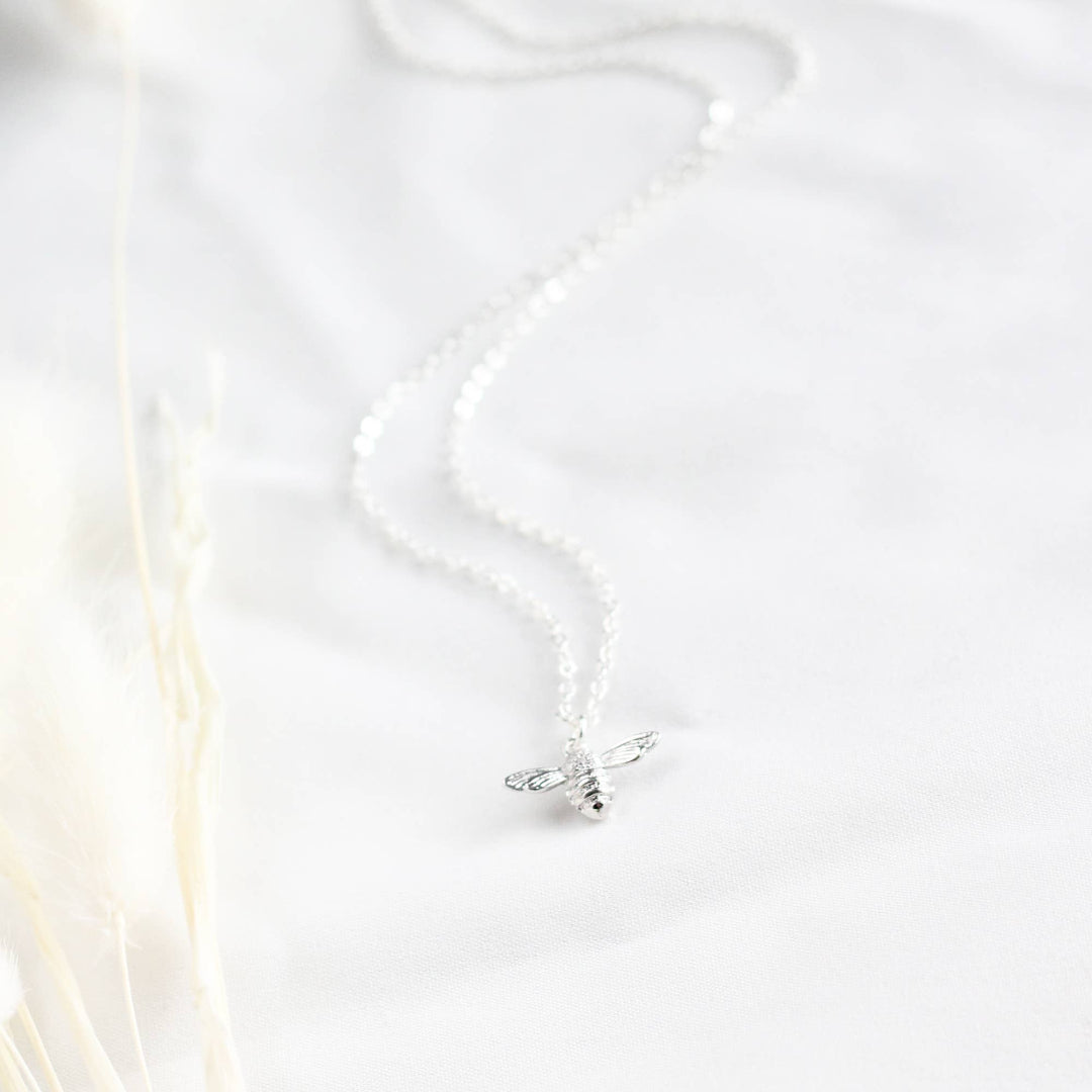 Silver necklace on a white fabric background