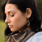 A pair of gold-colored horseshoe earrings. 