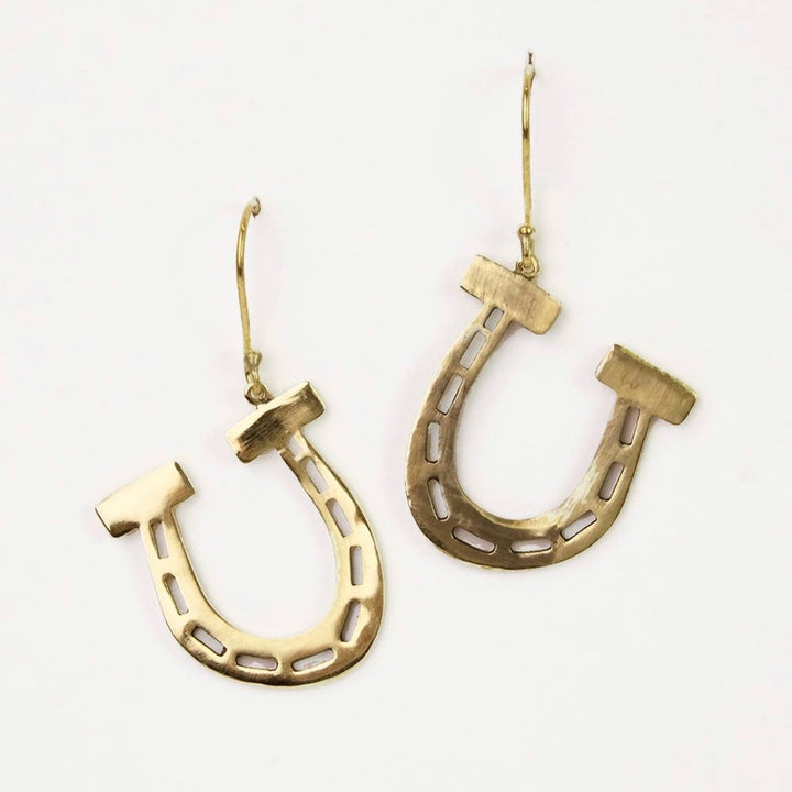 A pair of gold-colored horseshoe earrings. 