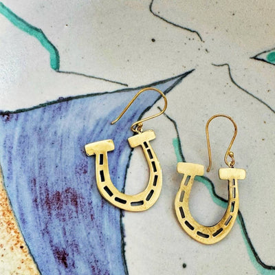 A pair of gold-colored horseshoe earrings. 