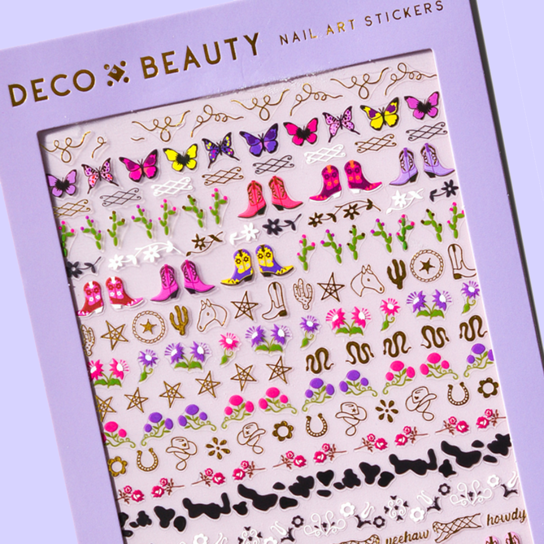 A sheet of cowboy-themed nail art stickers. The sheet is purple and has the brand name "Deco Beauty" printed on it. There's a section titled "Howdy" and instructions on how to apply the stickers. The stickers include various cowboy-themed designs like boots, horseshoes, stars, and butterflies.