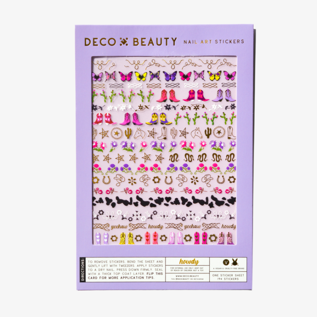 A sheet of cowboy-themed nail art stickers. The sheet is purple and has the brand name "Deco Beauty" printed on it. There's a section titled "Howdy" and instructions on how to apply the stickers. The stickers include various cowboy-themed designs like boots, horseshoes, stars, and butterflies.