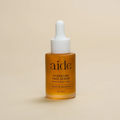 Aide Bodycare Hydrating Face Serum, featuring a small glass bottle with a dropper and a label with 'aide' logo, 'Hydrating Face Serum', and 'neroli & geranium' text, displayed on a light-colored surface. The serum is natural and available in Ottawa, Ontario, Canada.