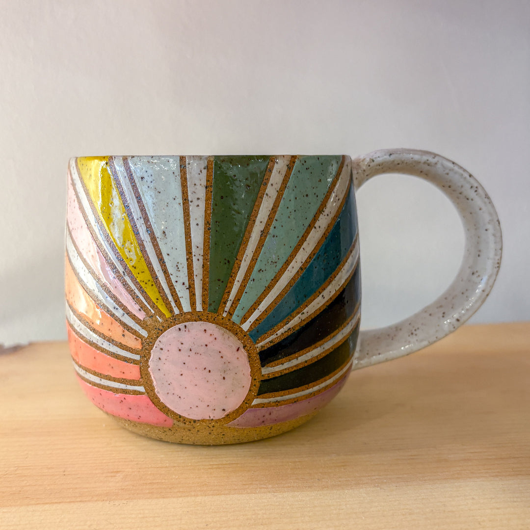 Colorful ceramic mug with abstract design on a wooden surface