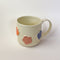 Flower Mug, a white ceramic mug with 3 dimensional flowers in a rainbow of colours.