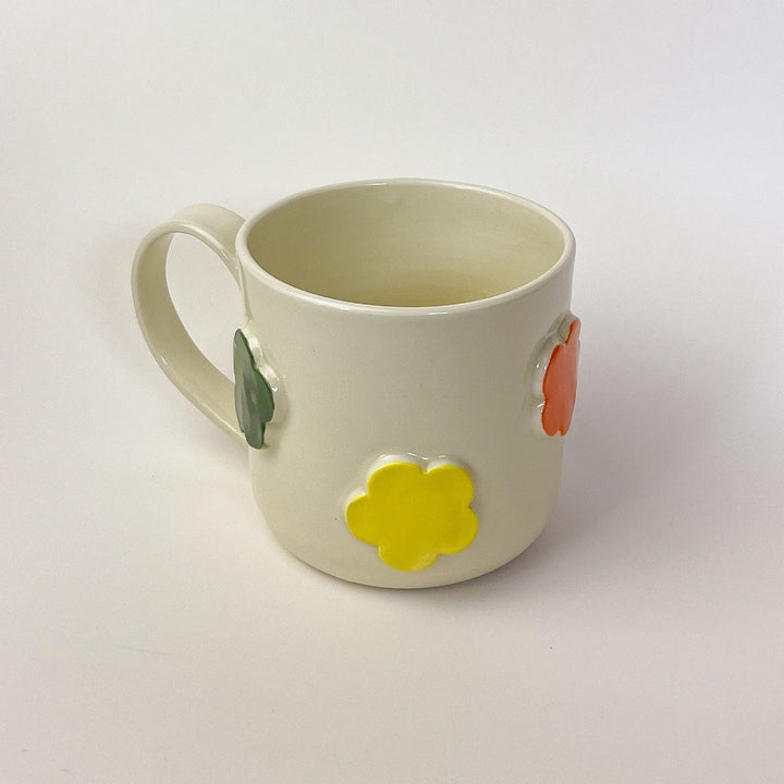 Flower Mug, a white ceramic mug with 3 dimensional flowers in a rainbow of colours.
