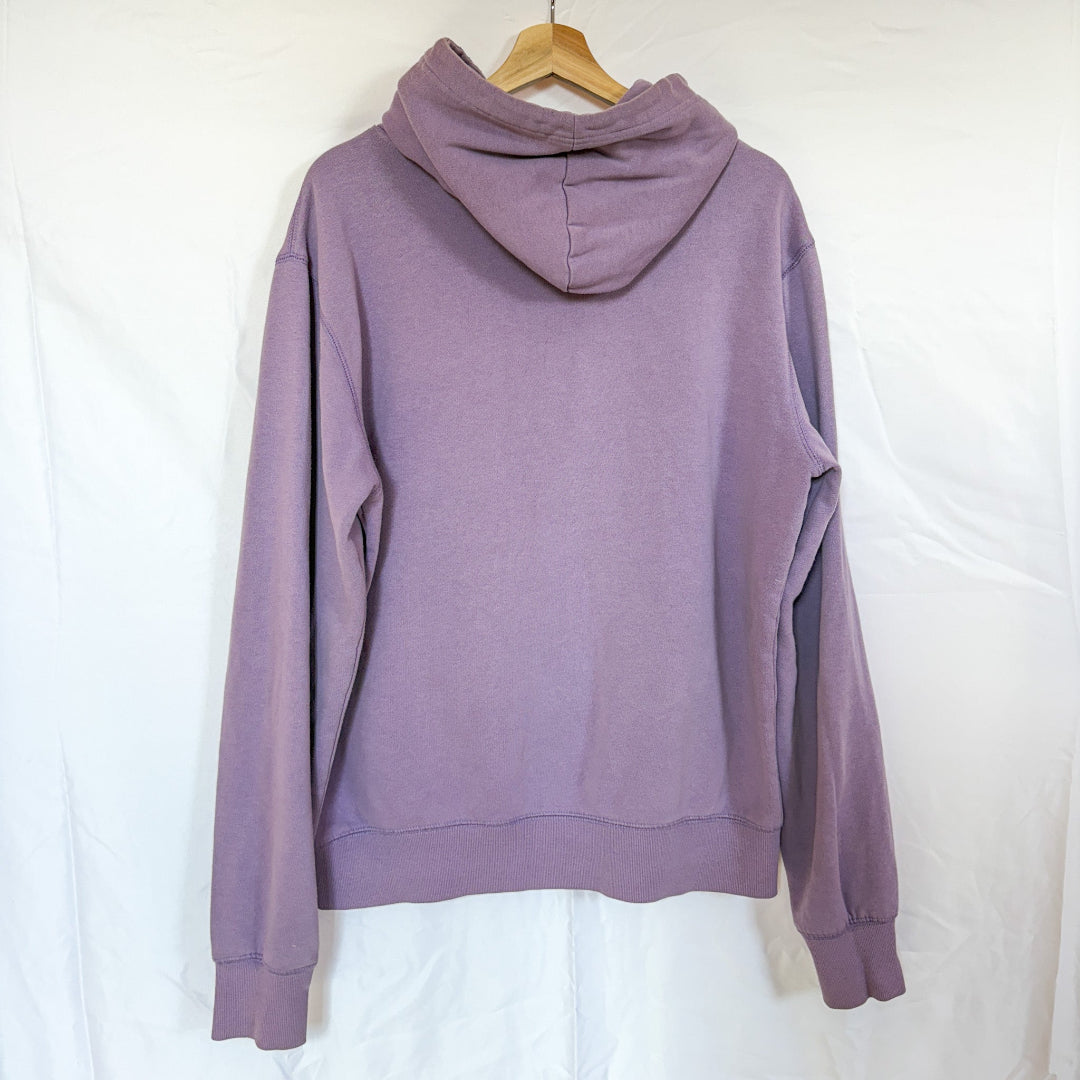 The back view of the same light purple Bluenotes hoodie, hanging on a wooden hanger against a white background. The back is plain.