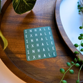Green card with 'INHALE EXHALE' text on a wooden surface with plants.