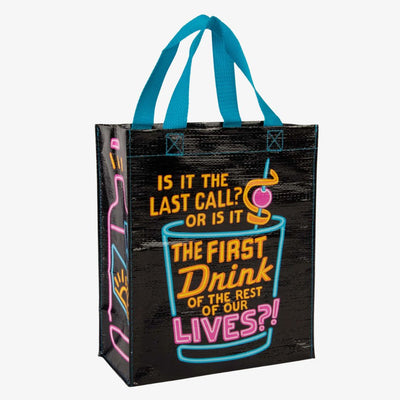 A black reusable tote bag with bright neon blue, pink, and yellow graphics. The front features a large cocktail glass with a cherry and straw, and text that reads 