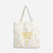 A white tote bag with a yellow smiley face design. The text 