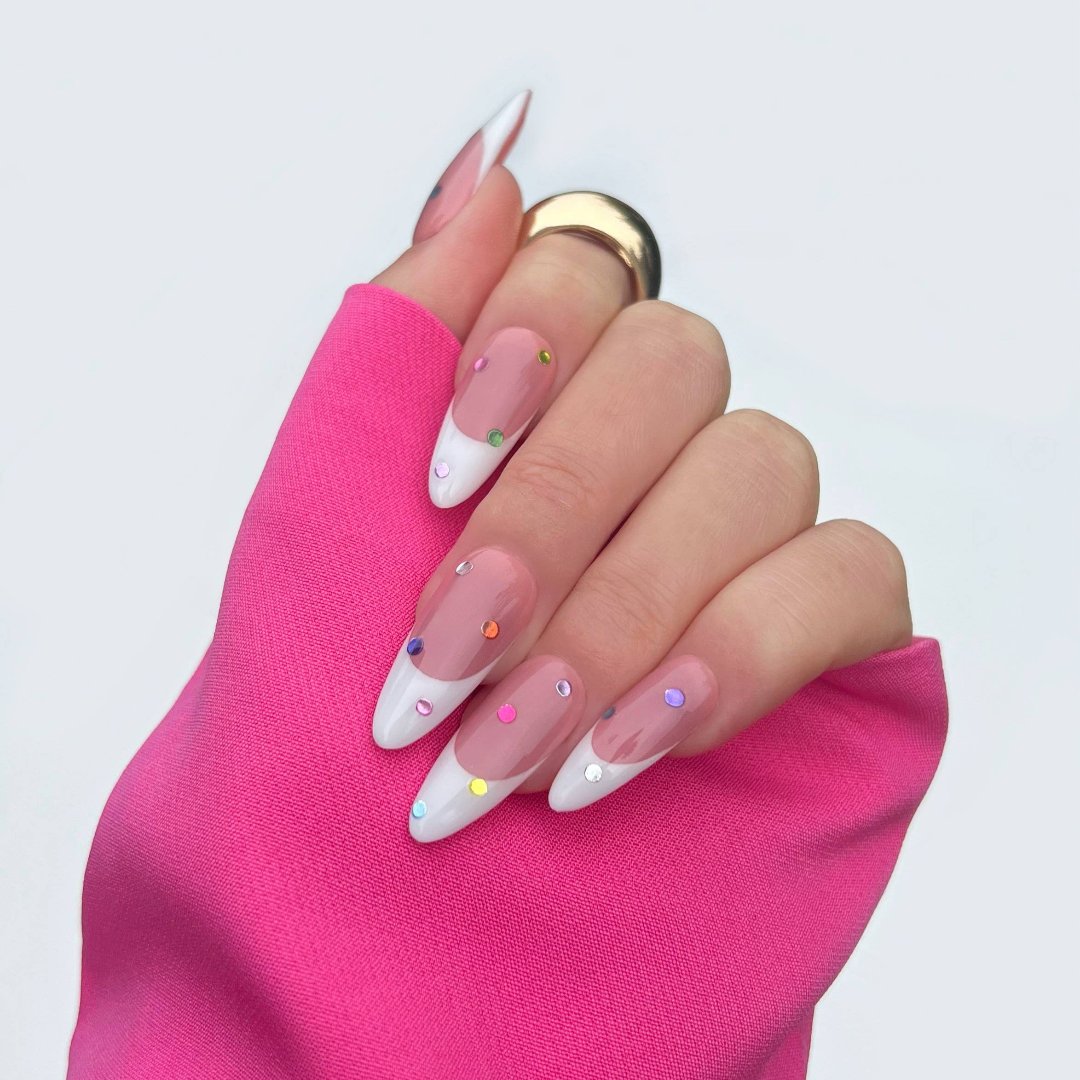 A sheet of colorful nail art stickers with various shapes like stars, hearts, flowers, and geometric designs. The sheet is holographic and has the brand name "Deco Beauty" printed on it. There's a section titled "JEWELS" and instructions on how to apply the stickers.