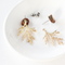 A pair of gold-colored branch earrings with detachable ear jackets. The earrings are displayed on a white plate with the ear jackets and posts visible.