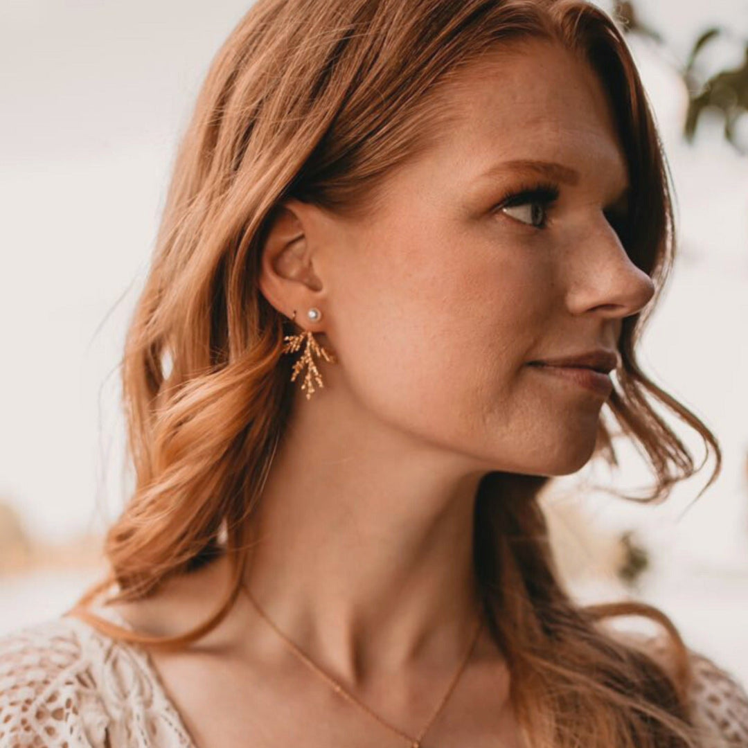 Woman wearing earrings with a blurred natural background