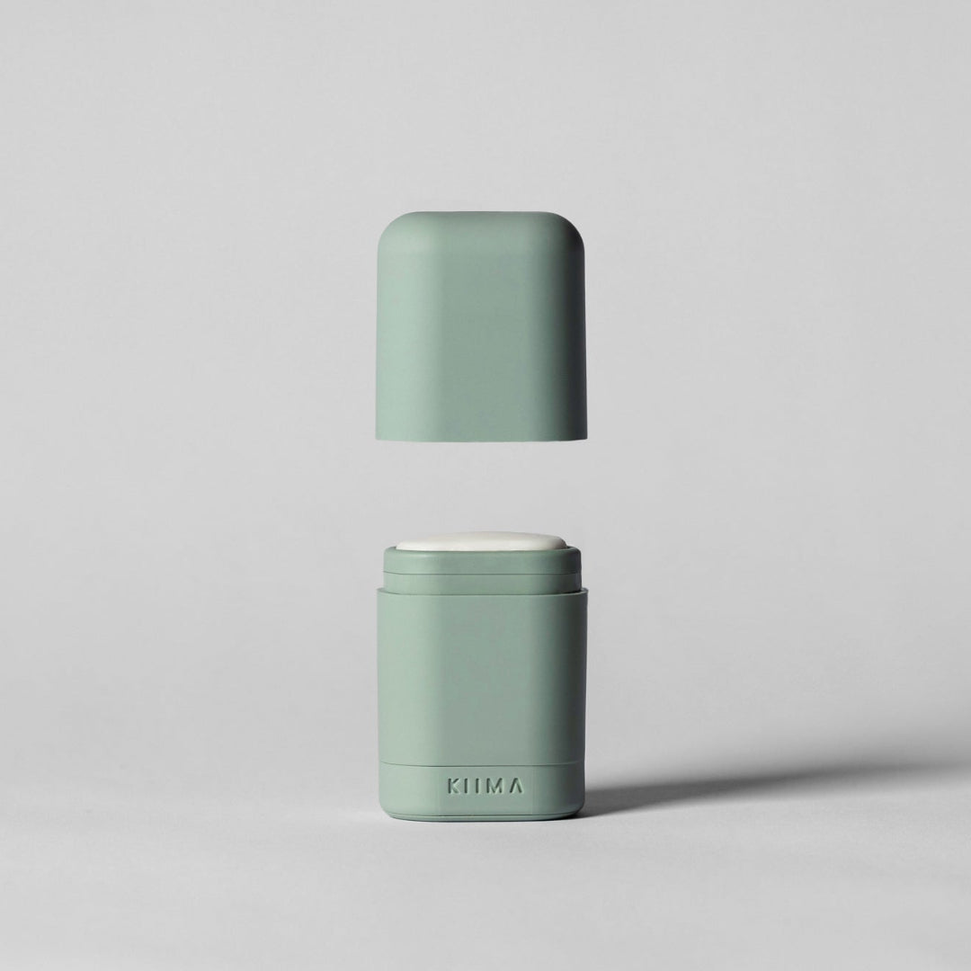 Two green containers with white lids on a light gray background