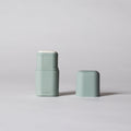 Two light green cylindrical containers on a gray background