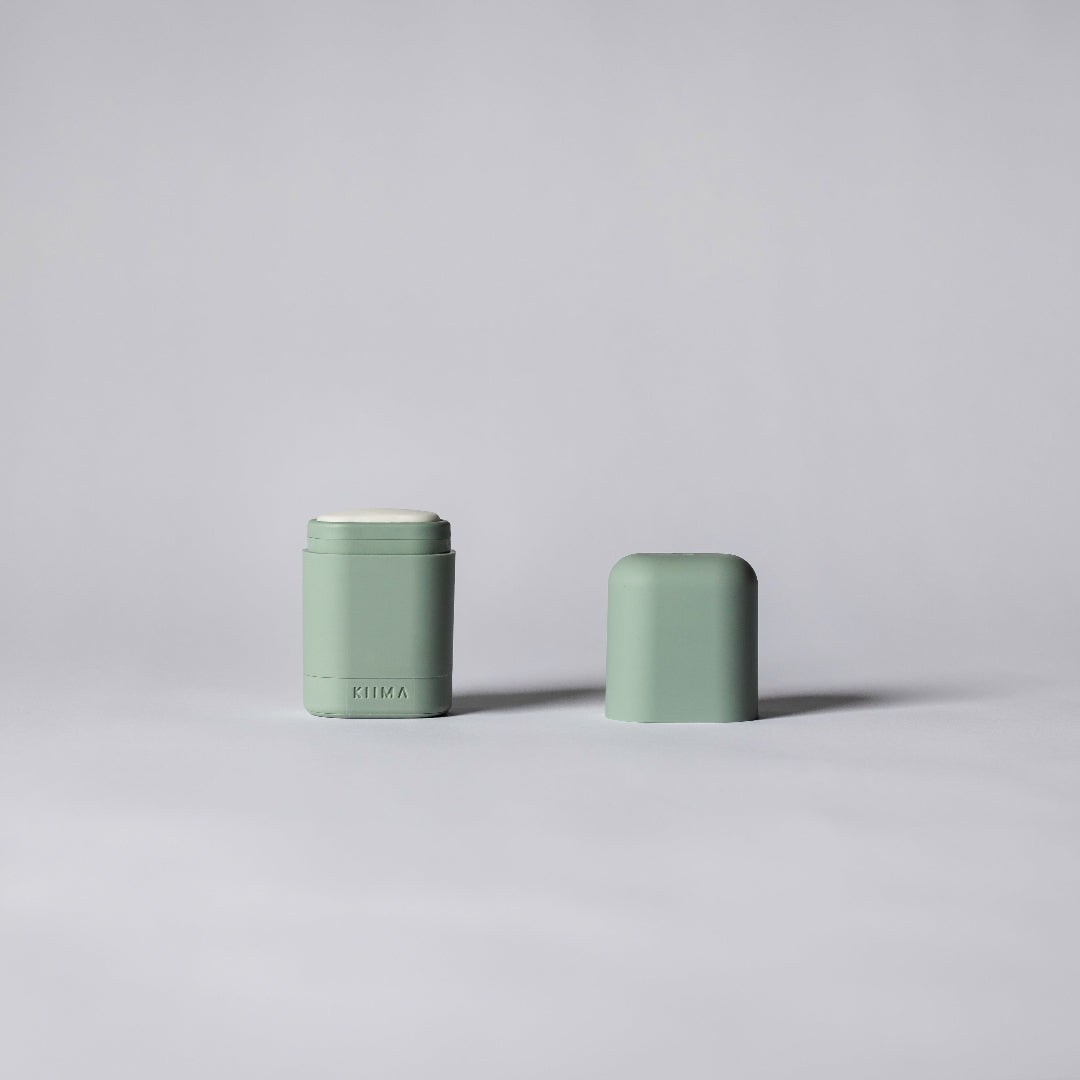 Two green cylindrical containers on a light gray background
