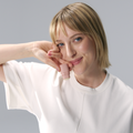 Woman wearing a white shirt against a gray background