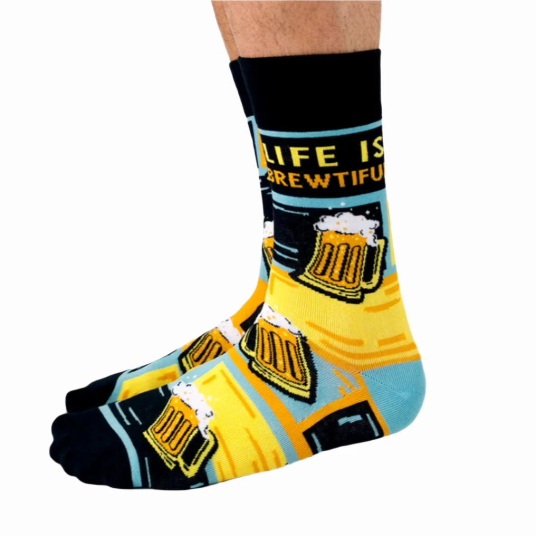 A pair of crew socks featuring a beer mug design. The socks are mostly black with yellow and blue accents. The text "Life is Brewtiful" is printed on the socks.