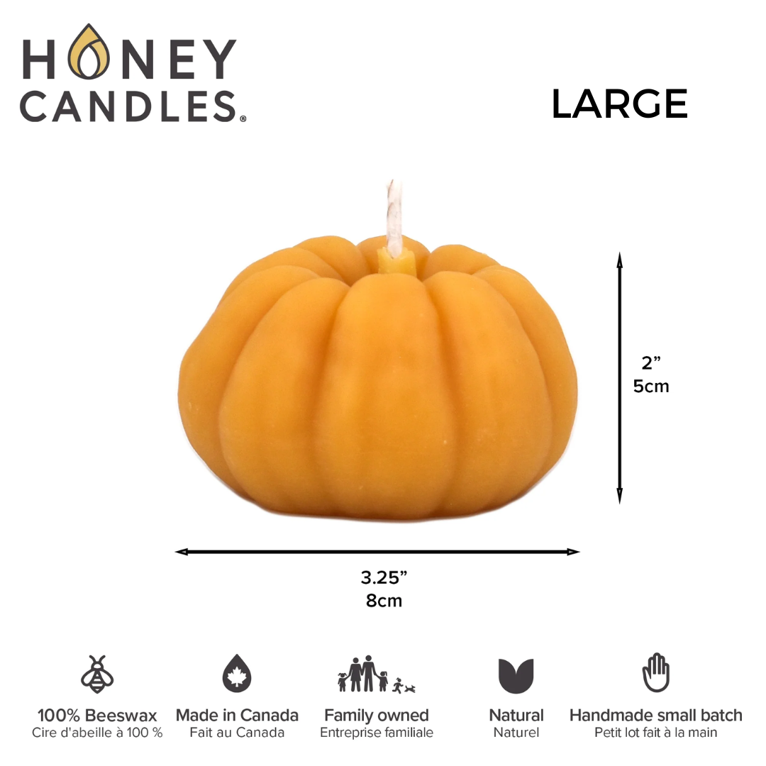 A small, pumpkin-shaped beeswax candle. The candle is orange with detailed ridges and a wick in the center.