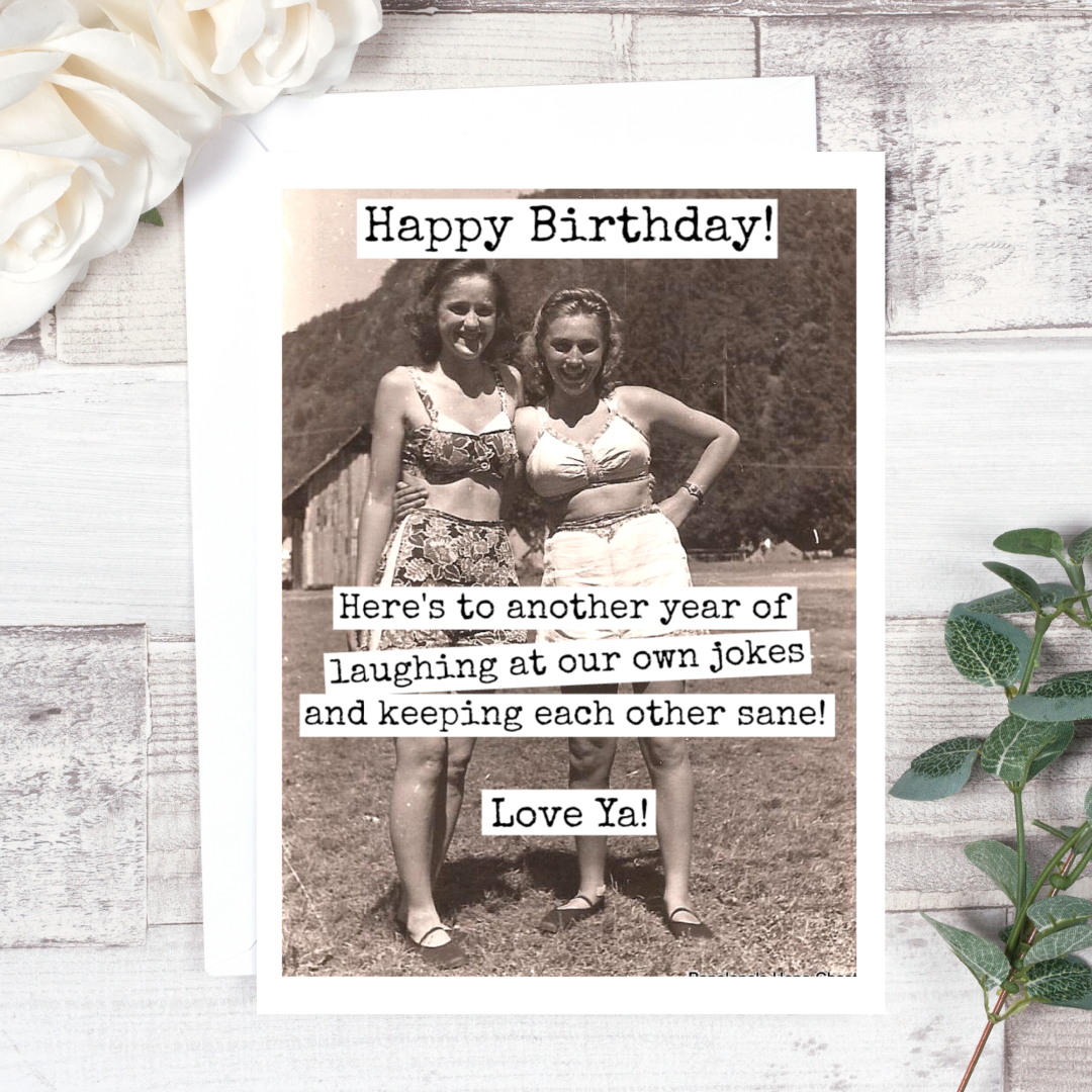 A birthday card with a vintage black and white photo of two women in swimsuits posing outdoors, smiling. Text on the card reads: "Happy Birthday! Here's to another year of laughing at our own jokes and keeping each other sane! Love Ya!"