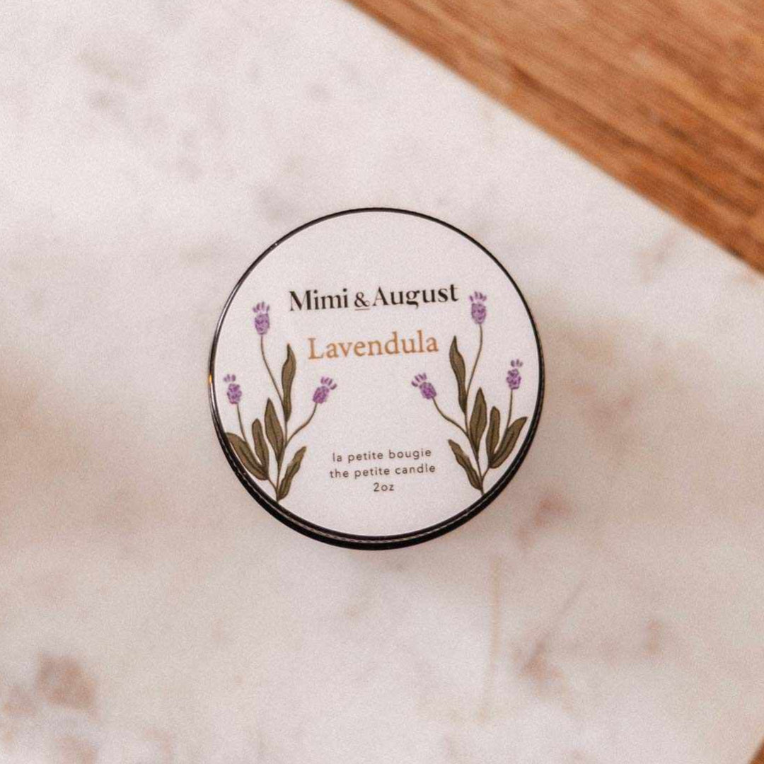 Small container of Mimi & August Lavender on a marble surface with a wooden background