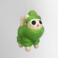 A felt ornament of a cat wearing a green hat, snowsuit and scarf.