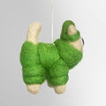 A felt ornament of a cat wearing a green hat, snowsuit and scarf.