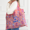Woman holding a pink tote bag with cowboy boot and hat designs, and 'Let's Go Girls' text.