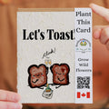 Seeded paper card with toast illustrations and 'Let's Toast' text, held by a hand.
