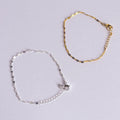 Gold and silver anklets on a light gray background
