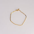 Gold bracelet on a light gray background