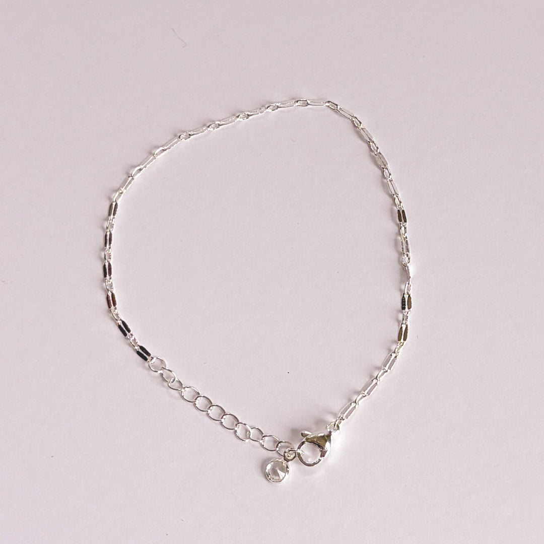Silver bracelet on a light gray background