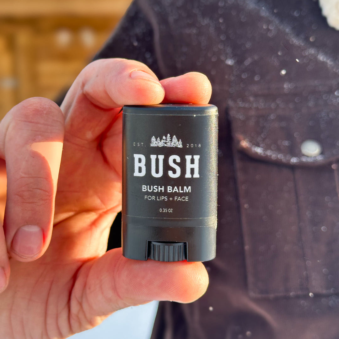 Hand holding a stick of Bush balm against a blurred background