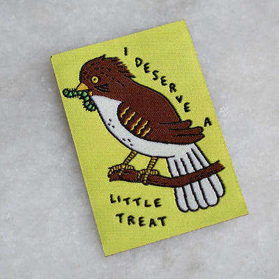 Embroidered patch with a bird design and text on a yellow background