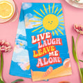 Towel with sun and text 'Live Laugh Leave Me Alone' on a pink background