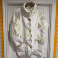Quilted jacket with floral patterns hanging on a door