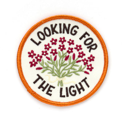 Patch with embroidered flowers and text 'Looking for the Light' on a white background