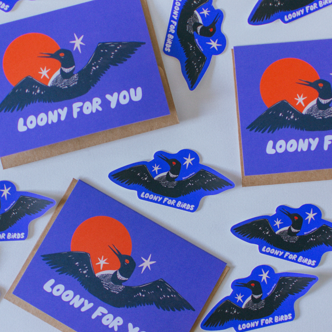 A set of die-cut stickers and a matching square card featuring a stylized loony bird illustration. The design shows a dark blue bird with outstretched wings over a bright orange sun and white stars, with the text 'LOONY FOR BIRDS' on the card and smaller 'LOONY FOR BIRDS' text on the stickers.