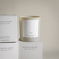 North + Rose scented candle and packaging on a light background