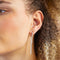 A set of silver earrings with interchangeable charms. The set includes two pairs of silver hoop earrings and three charms: a pearl, the word 