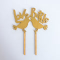 Gold 'Love Birds' cake topper on a white background