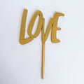 Wooden 'LOVE' cake topper on a white background