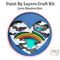 Heart-shaped craft kit with rainbow and cloud design on a white background