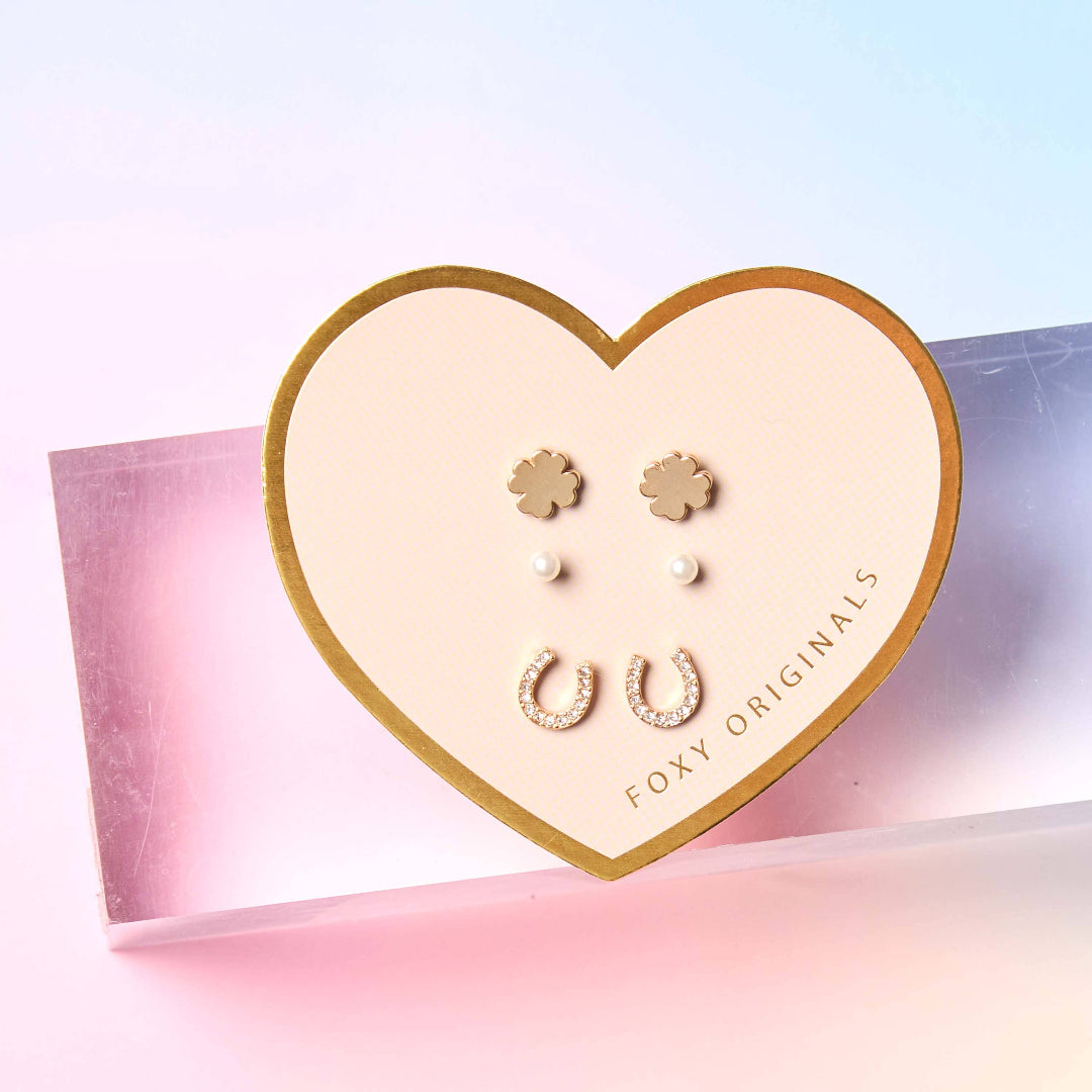 Heart-shaped jewelry display card with earrings on a pink and blue gradient background