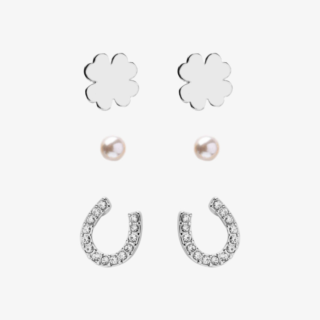 Set of silver flower and horseshoe earrings with pearls on a white background