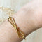 A gold-toned bangle bracelet with a bow design.