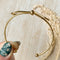 A gold-toned bangle bracelet with a bow design.