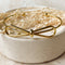 A gold-toned bangle bracelet with a bow design.