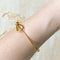 A gold-toned bangle bracelet with a bow design.