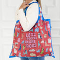 A colorful tote bag with a dog-themed design. The bag is covered in illustrations of various dog breeds in different poses, with the text "Less People More Dogs" printed in the center.